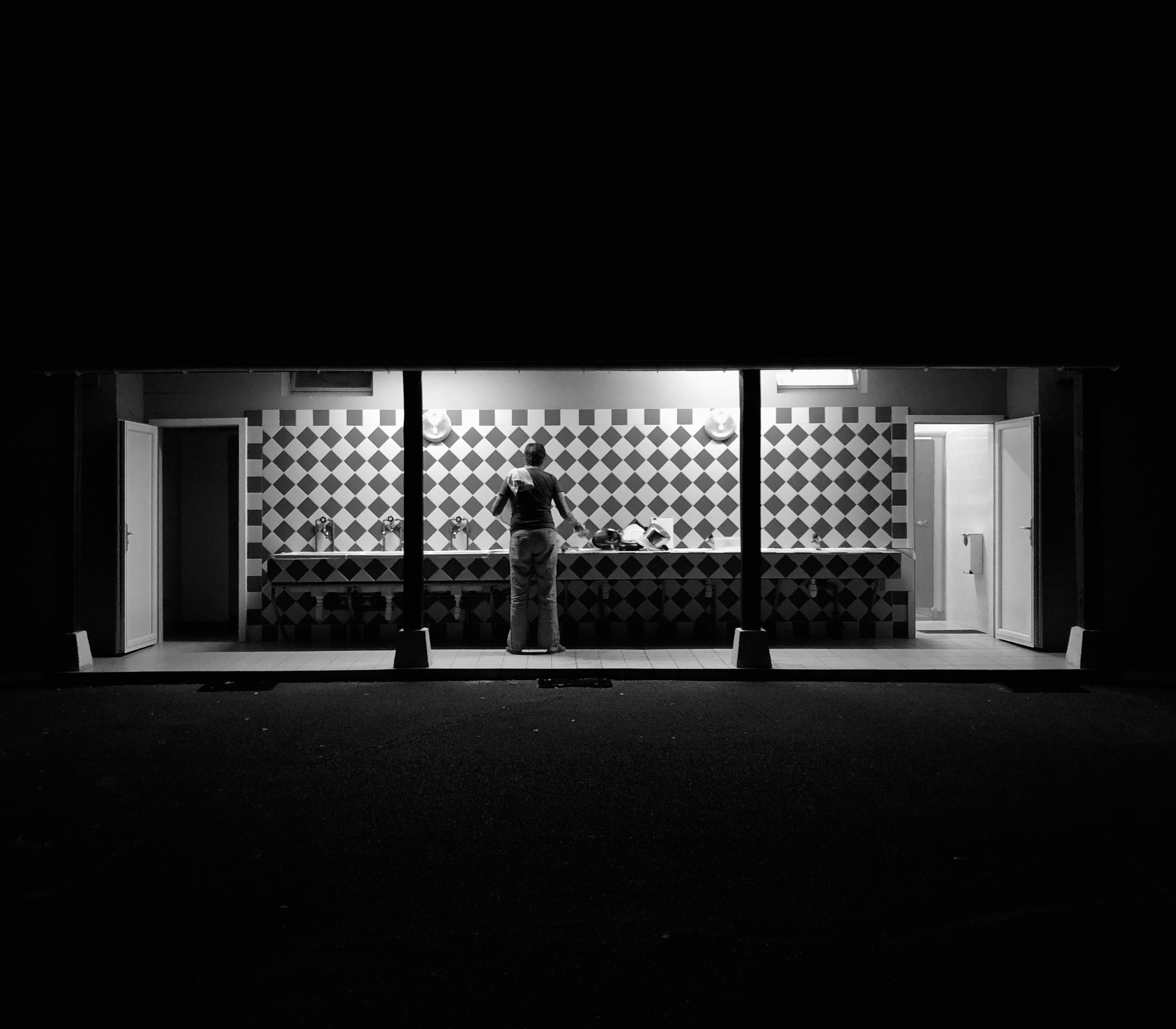 grayscale photo of person walking on hallway